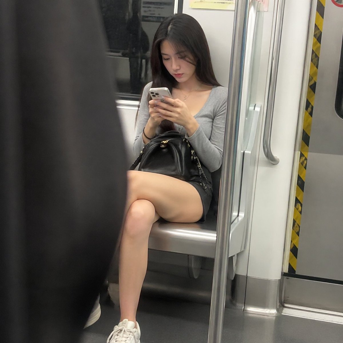 地铁车厢里看手机的美丽女人